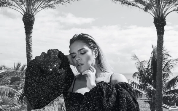 HD desktop wallpaper featuring a monochrome image of a woman in elegant attire posing with palms in the background.