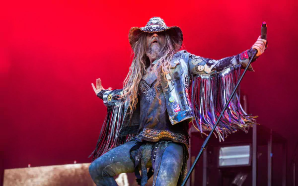 Rob Zombie performing on stage, a vibrant HD desktop wallpaper with a red background.