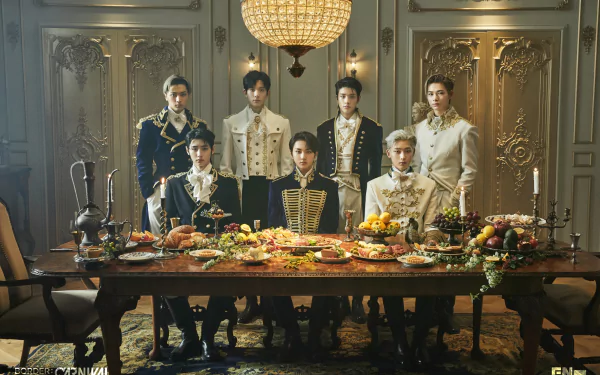 Seven young men in ornate military-style outfits pose around a lavish banquet table in an opulent room; music-themed 2K Quad HD PC desktop wallpaper.