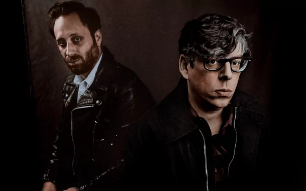 HD wallpaper featuring two band members, posing for a dark, moody portrait suitable as a desktop background.