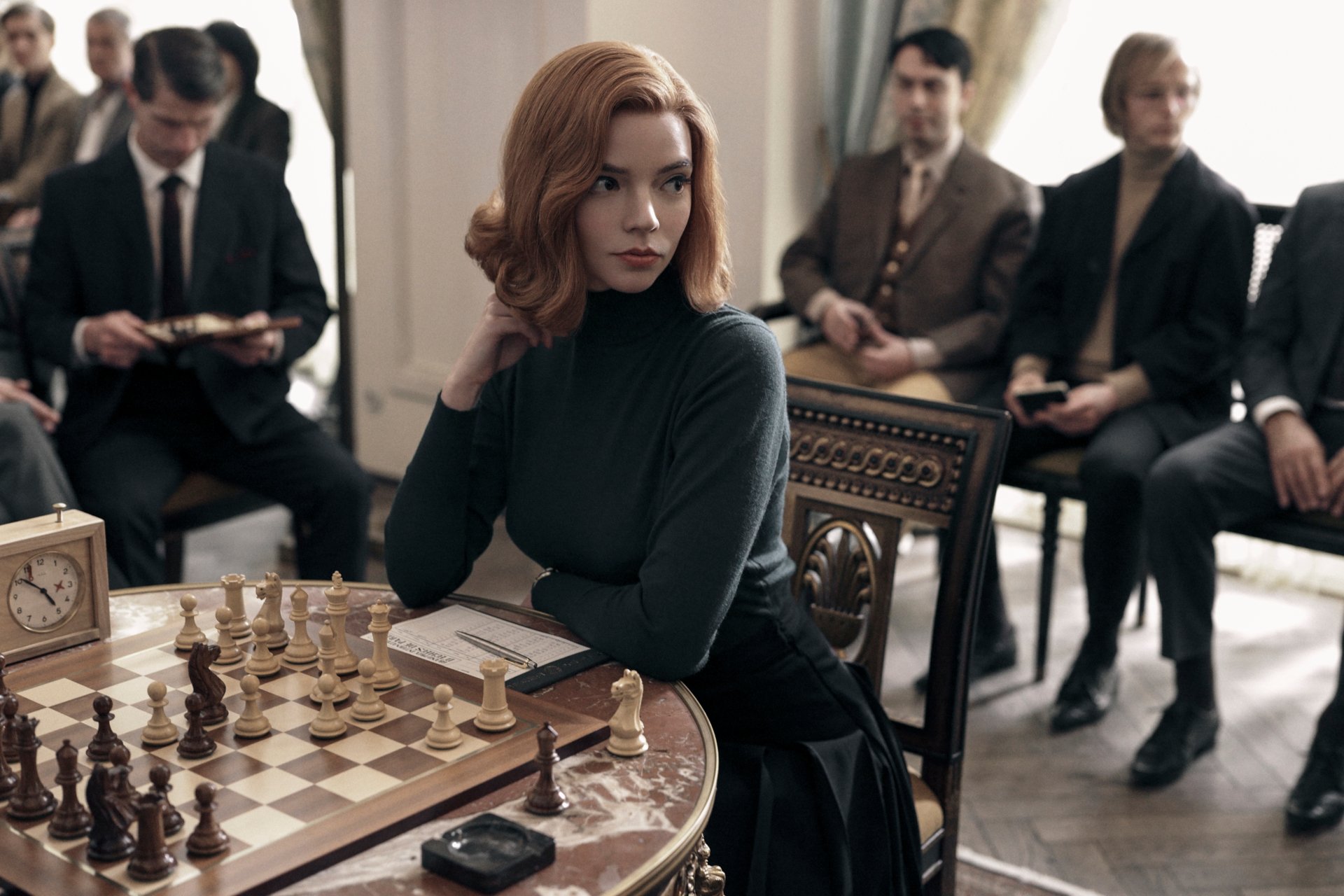 Beth Harmon, portrayed by Anya Taylor-Joy in the TV show The Queen's Gambit, sits thoughtfully at a chessboard in this HD PC desktop wallpaper and background.