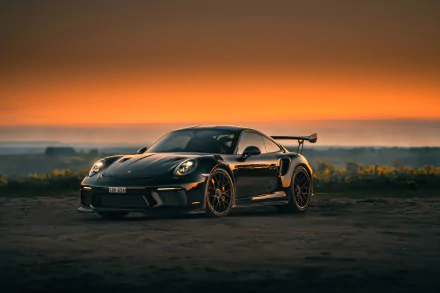 A black Porsche 911 GT3 sports car parked on a road at sunset, captured in stunning 4K Ultra HD quality.