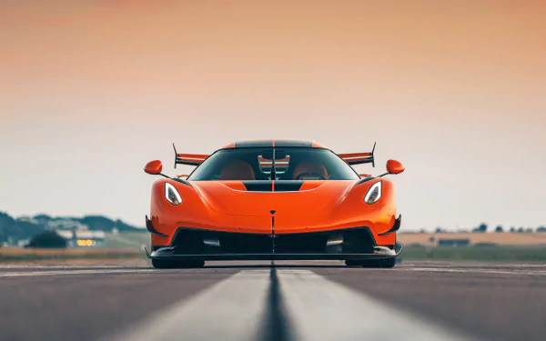 Front view of an orange Koenigsegg Jesko supercar on a runway, captured in stunning 8K Ultra HD for a PC desktop wallpaper background.