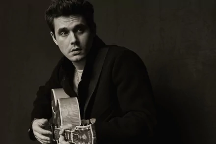 HD wallpaper featuring a monochrome portrait of a man holding a guitar, providing an artistic backdrop for desktops.