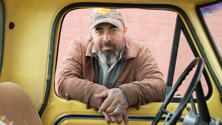 Man leaning on the window frame of a yellow vintage truck, HD desktop wallpaper and background.