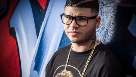 HD desktop wallpaper featuring Farruko posing confidently against a vibrant graffiti background, showcasing a blend of urban art and modern music culture.