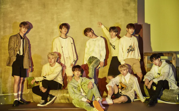 Stray Kids boy band poses for a 4K Ultra HD K-pop music desktop wallpaper with stylish outfits against a textured golden background.