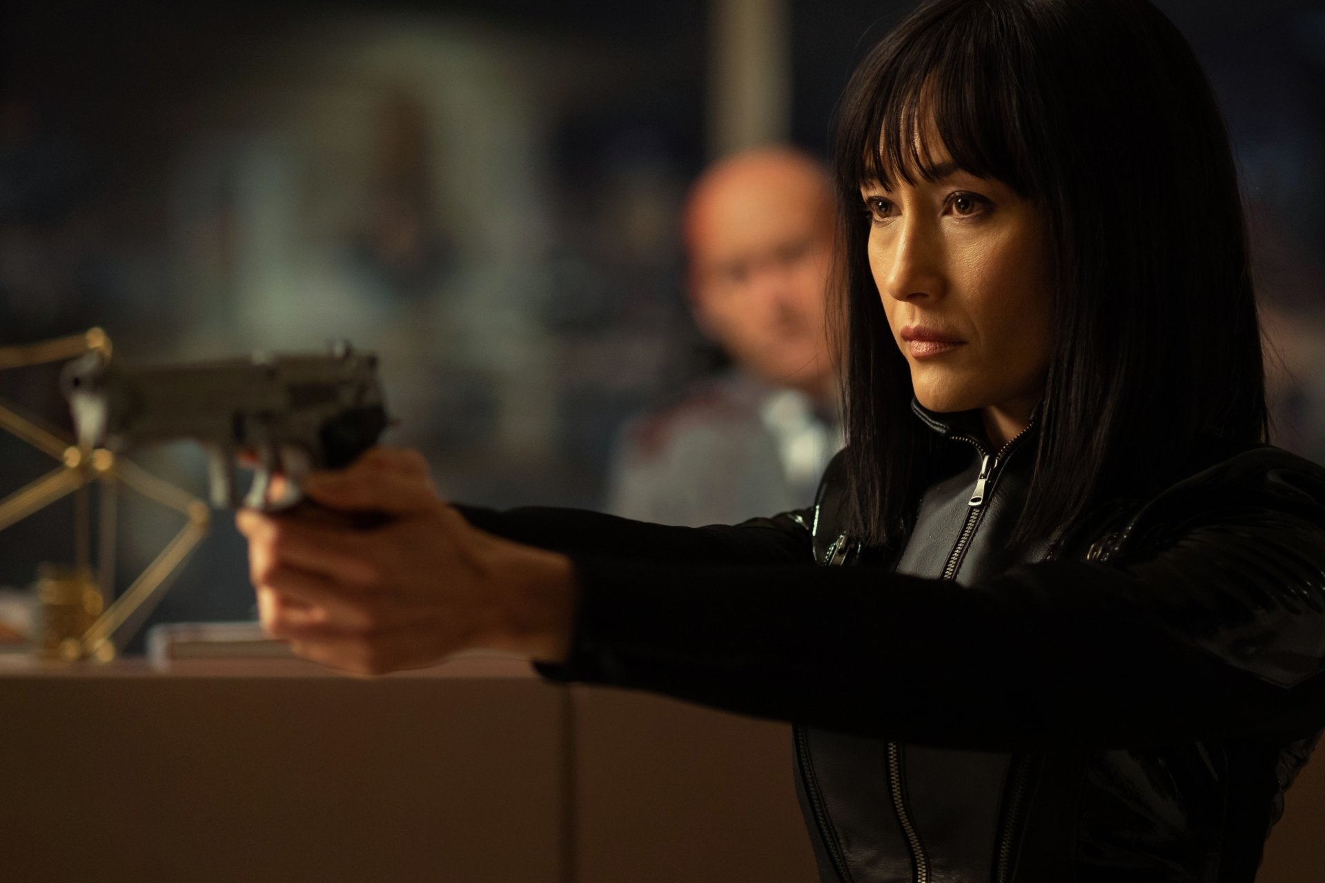 Maggie Q in a tense scene from the movie The Protégé, showcased in a 4K Ultra HD PC desktop wallpaper and background.