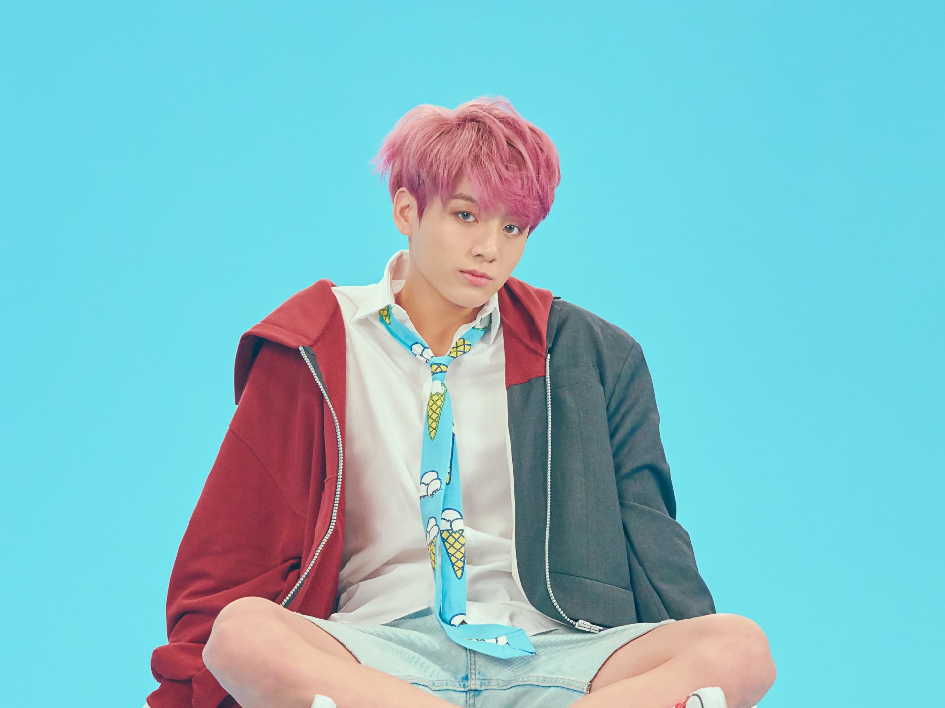 Jungkook, K-pop singer from BTS, posed against a bright blue background in a vibrant 4K Ultra HD desktop wallpaper.