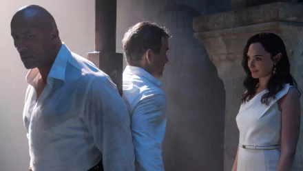 HD desktop wallpaper featuring Gal Gadot, Ryan Reynolds, and Dwayne Johnson from the movie Red Notice, set against a dramatic, shadowed background.