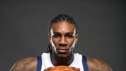HD desktop wallpaper featuring a basketball player in a white and blue jersey holding a ball, with a focused expression, against a dark background.