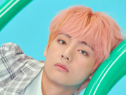 Close-up 4K Ultra HD wallpaper of V (Kim Taehyung), the K-pop singer from BTS, with pink hair and a soft expression set against a bright blue background.