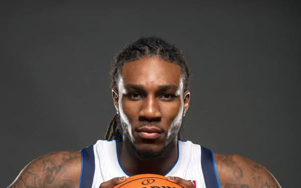 HD desktop wallpaper featuring a basketball player in a white and blue jersey holding a ball, with a focused expression, against a dark background.