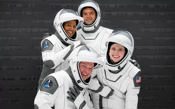 HD desktop wallpaper featuring a group of four astronauts in SpaceX suits from Inspiration4 mission, smiling against a space-themed background.