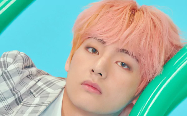 Close-up 4K Ultra HD wallpaper of V (Kim Taehyung), the K-pop singer from BTS, with pink hair and a soft expression set against a bright blue background.