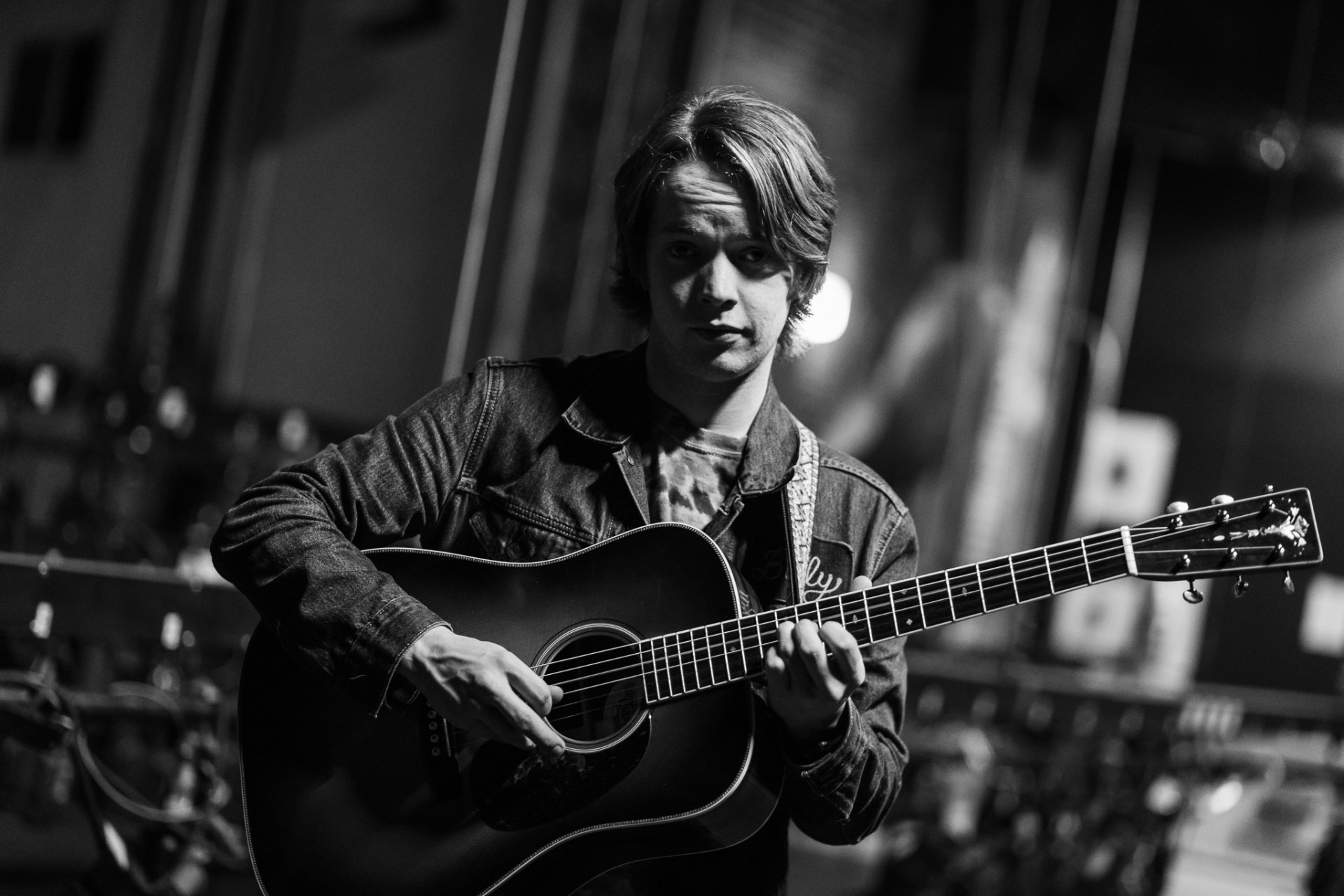 HD desktop wallpaper featuring black and white photo of musician Billy Strings playing an acoustic guitar.