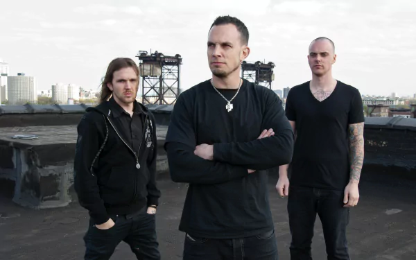 Three musicians pose confidently against an industrial backdrop, embodying the essence of Tremonti. This HD wallpaper captures their edgy style and musical energy.