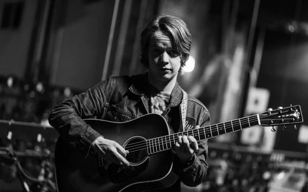 HD desktop wallpaper featuring black and white photo of musician Billy Strings playing an acoustic guitar.