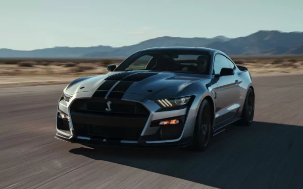 4K Ultra HD PC desktop wallpaper of a Ford Mustang Shelby GT500 muscle car driving along a desert road — high-detail vehicle background.