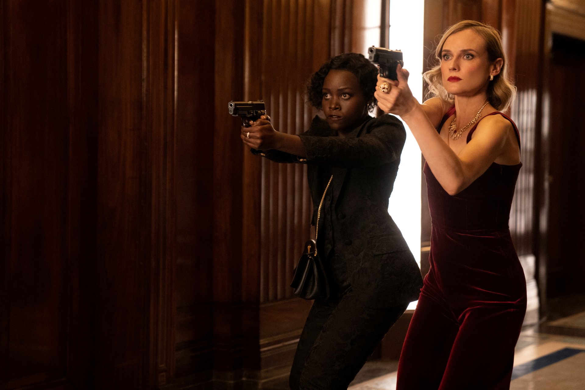Lupita Nyong'o and Diane Kruger aim guns in a scene from the movie The 355, captured in 4K Ultra HD for a PC desktop wallpaper.