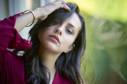 HD PC desktop wallpaper and background featuring a black-haired woman model, hand in her hair, soft green bokeh behind her.