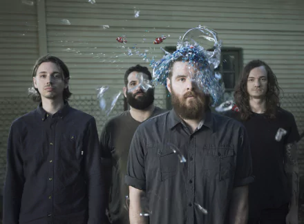 HD desktop wallpaper featuring the members of Manchester Orchestra with a dynamic splash of water frozen in motion around one of their heads, providing a creative and engaging background for fans.