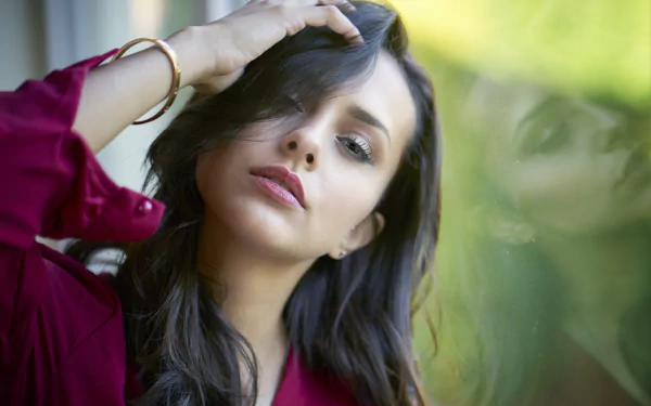 HD PC desktop wallpaper and background featuring a black-haired woman model, hand in her hair, soft green bokeh behind her.
