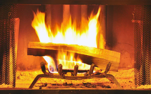 HD desktop wallpaper featuring a warm, glowing fireplace with a log on fire.