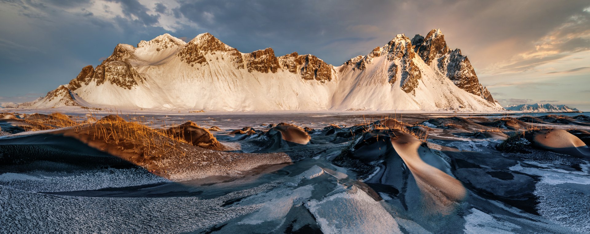 Vestrahorn mountain nature scene in Iceland at sunrise: jagged, snow-capped peaks over black-sand and icy foreground — 8K Ultra HD PC desktop wallpaper and background.