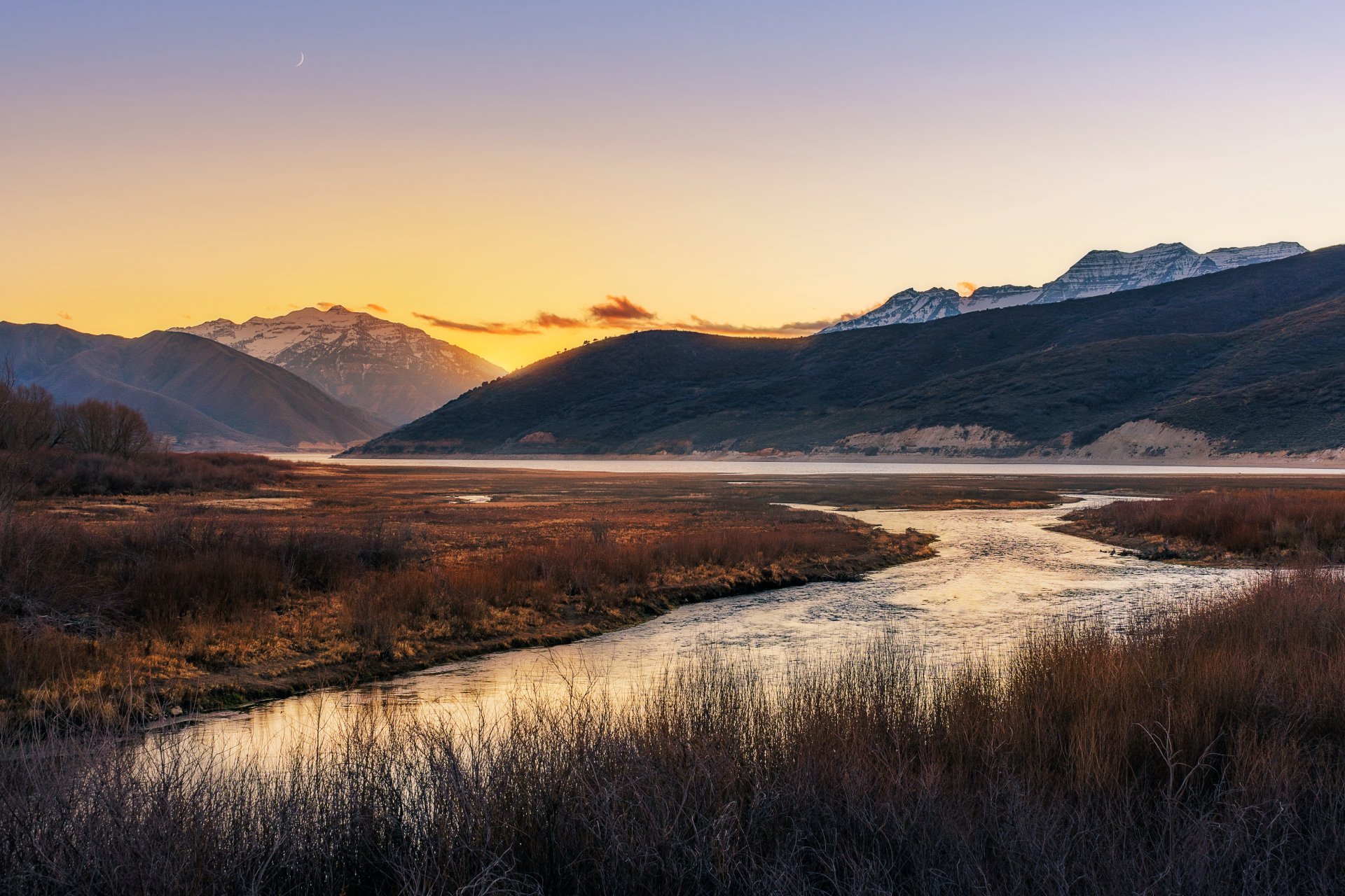 A serene mountain valley at sunset with a winding river, captured in vivid detail as a 4K Ultra HD PC desktop wallpaper and background.