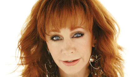 HD desktop wallpaper featuring a close-up of a red-haired woman with blue eyes and earrings, suitable as a background image.