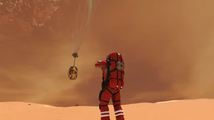 A space engineer in a red suit stands on a sandy surface, watching a cargo pod descend from the sky amidst a dramatic orange backdrop, encapsulating the adventure of the game.