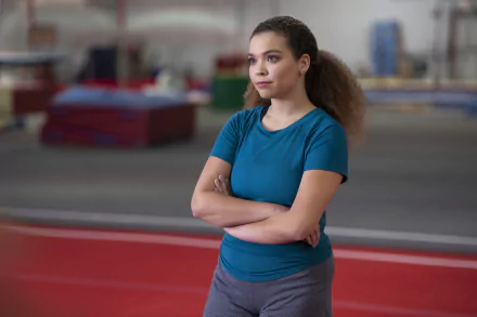 Young woman with arms crossed in a gym, thoughtful expression — Cobra Kai TV show 2K Quad HD PC desktop wallpaper and background.