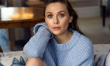 HD desktop wallpaper of celebrity Elizabeth Olsen wearing a cozy light blue sweater, sitting indoors with a thoughtful expression.