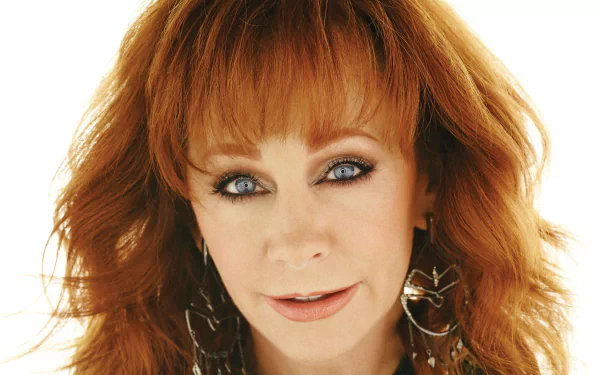 HD desktop wallpaper featuring a close-up of a red-haired woman with blue eyes and earrings, suitable as a background image.