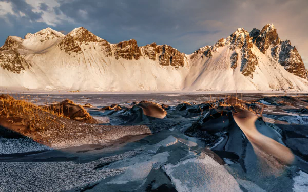 Vestrahorn mountain nature scene in Iceland at sunrise: jagged, snow-capped peaks over black-sand and icy foreground — 8K Ultra HD PC desktop wallpaper and background.