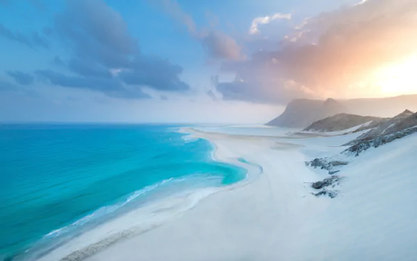 8K Ultra HD PC desktop wallpaper and background: beach coastline with turquoise water, white sand, distant cliffs and a glowing sunset sky — serene nature scene.
