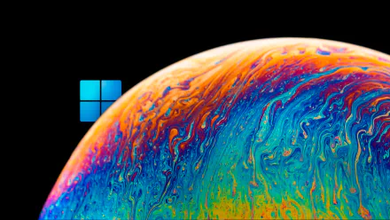 4K Ultra HD PC desktop wallpaper featuring the Windows 11 logo with a vibrant, colorful, swirling planet-like surface against a black background.