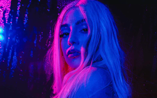 HD PC desktop wallpaper of Ava Max with neon blue and pink lighting, capturing a moody, vibrant music-themed portrait.
