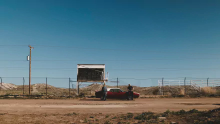 8K Ultra HD PC desktop wallpaper: scene from TV show Better Call Saul — red car and two figures by a rundown roadside billboard under a wide blue sky.