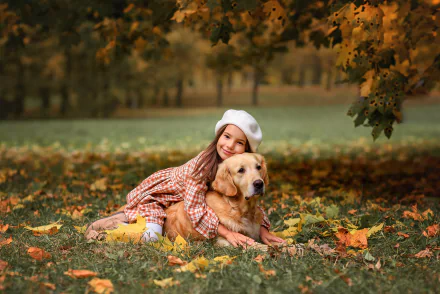 A child in autumn attire hugs a golden retriever while lying on fallen leaves, captured in an HD desktop wallpaper photography.