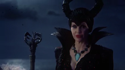 HD PC desktop wallpaper: Maleficent from the TV show Once Upon a Time — horned, black-clad villainess with turquoise pendant and twisted staff against a stormy night sky.