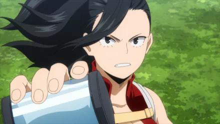 Momo Yaoyorozu from My Hero Academia reaches forward with a determined look, holding a metal cylinder against a grassy HD PC desktop wallpaper background.