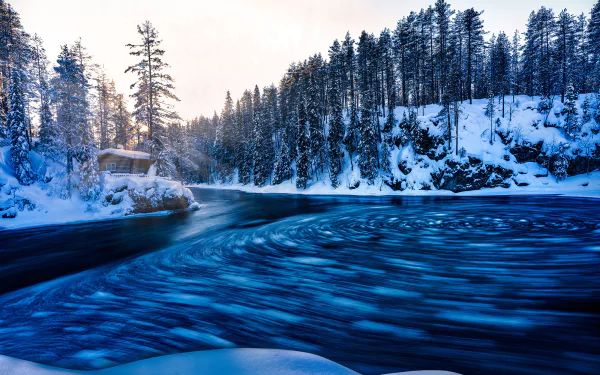 HD PC desktop wallpaper and background: Finland winter river swirling through snow-covered pines and rocky banks at dawn.