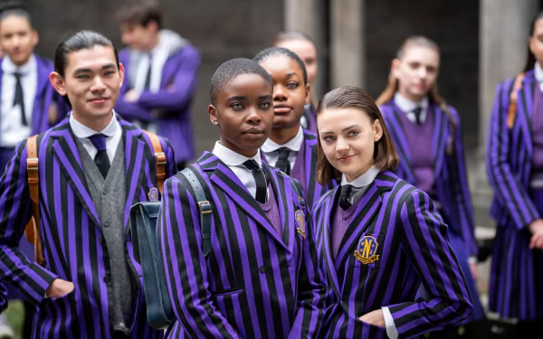 HD PC desktop wallpaper featuring characters from the TV show Wednesday dressed in striking purple and black striped school uniforms outdoors.