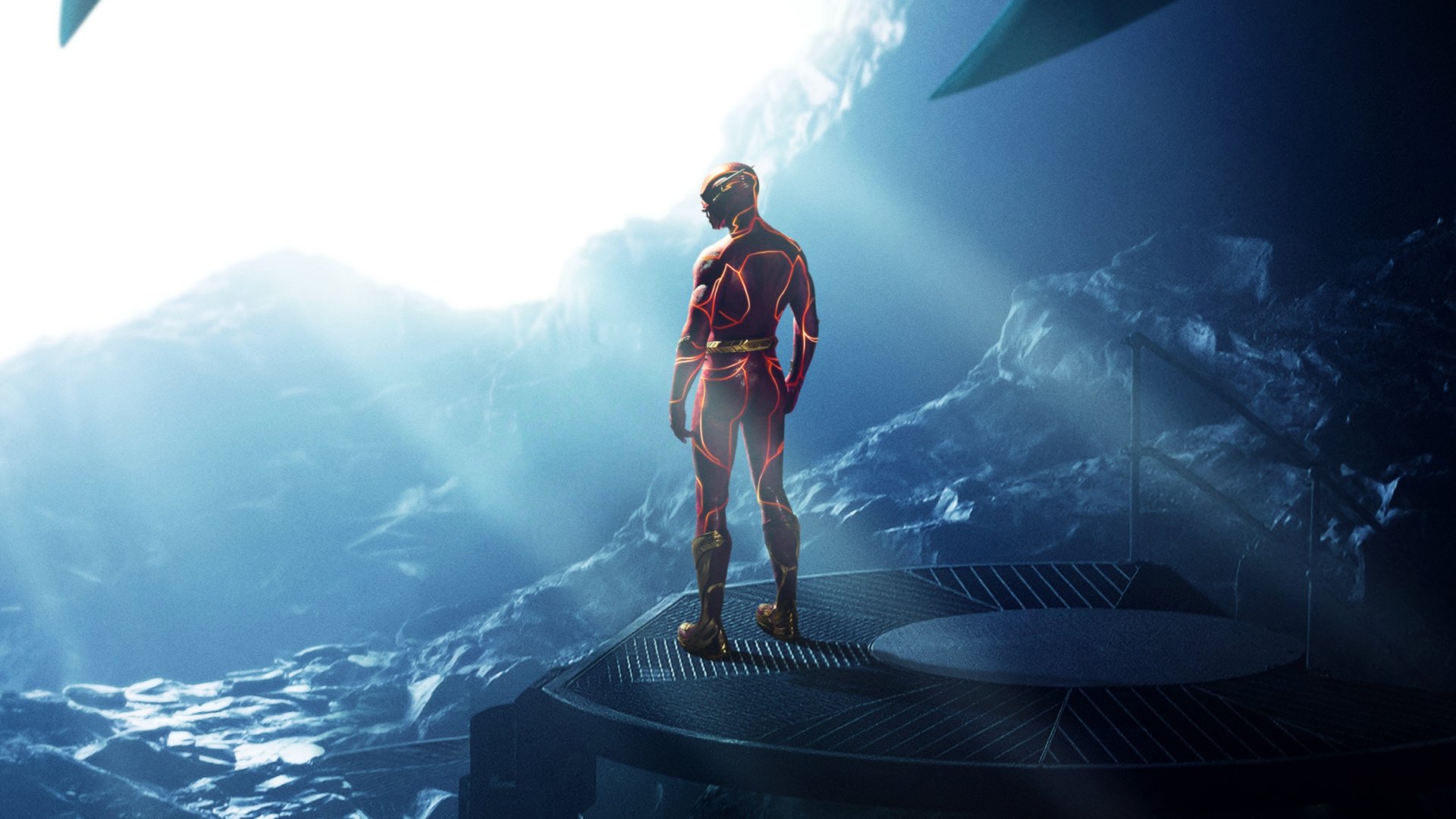 The Flash (2023) movie 2K Quad HD PC desktop wallpaper — The Flash stands on a rocky platform bathed in blue light and mist, facing a bright opening.
