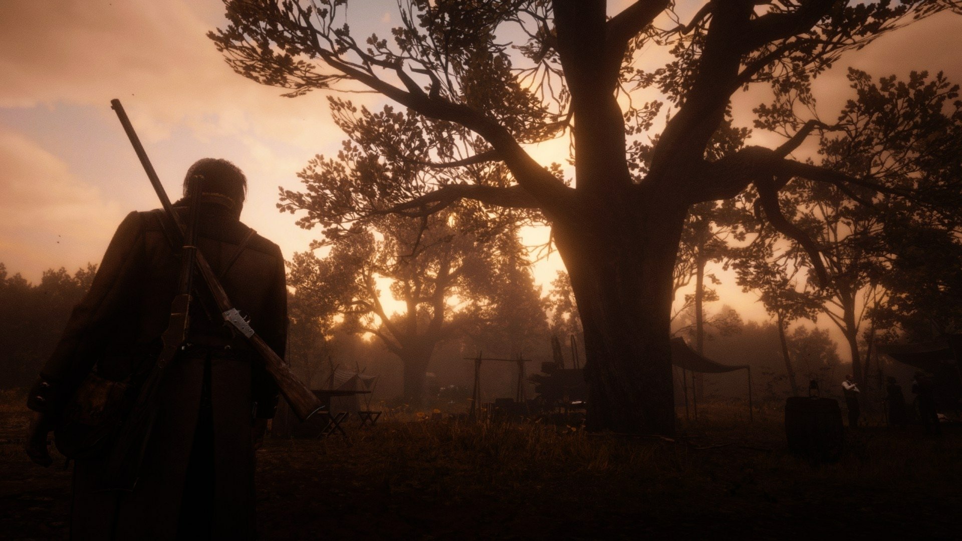 Arthur Morgan from Red Dead Redemption 2 stands near a large tree at dusk in this HD PC desktop wallpaper and background.