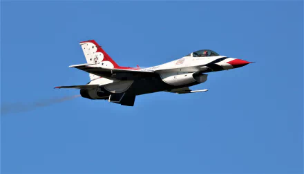 United States Air Force Thunderbirds General Dynamics F-16 Fighting Falcon performing in an air show against a clear blue sky, captured in 4K Ultra HD quality.