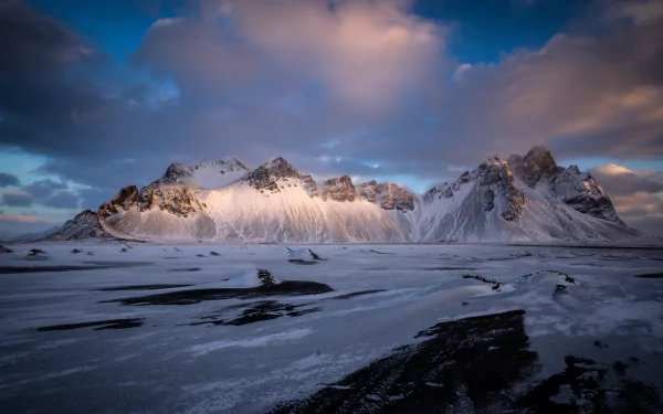 Snow-covered Vestrahorn mountains under a dramatic sky, captured in stunning 4K Ultra HD for a nature-themed PC desktop wallpaper.
