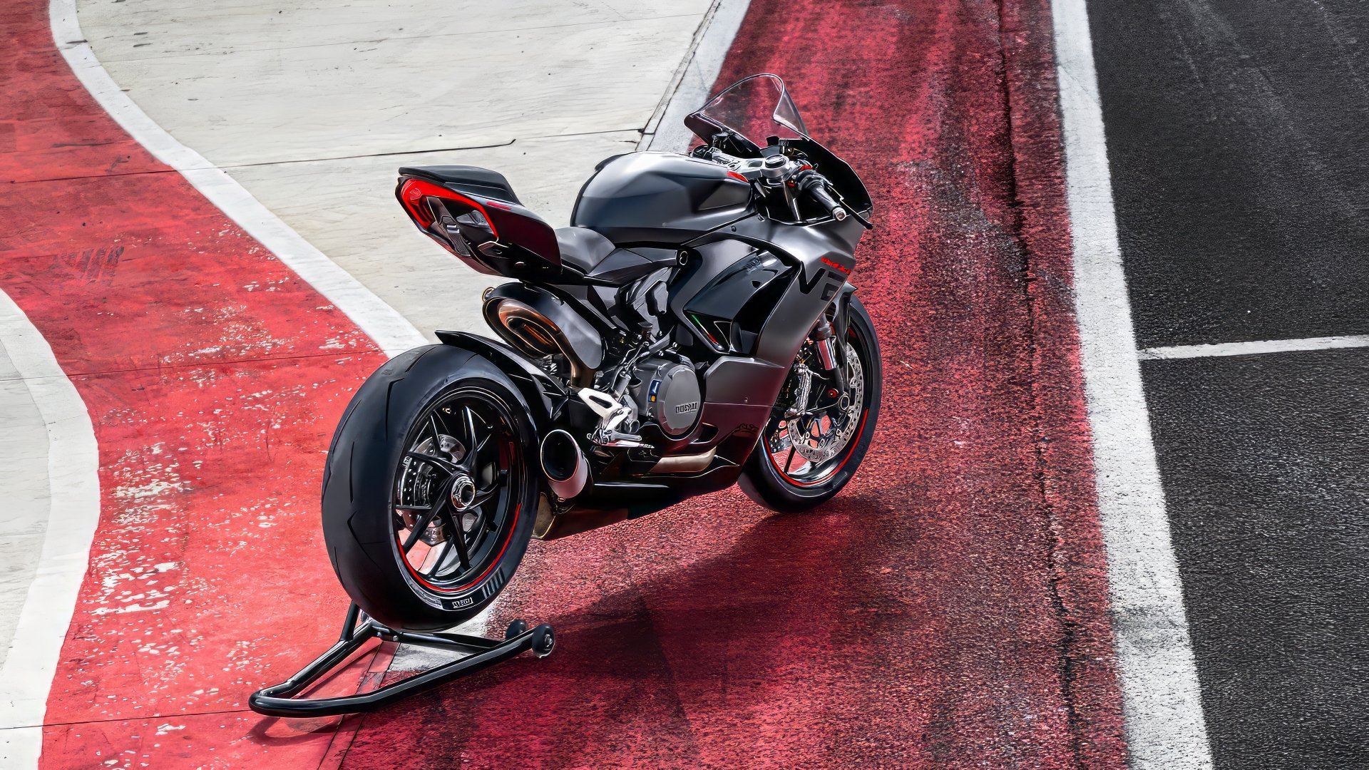 HD desktop wallpaper featuring a Ducati Panigale V2 motorcycle parked on a racing track, highlighting its sleek design and sporty aesthetics.